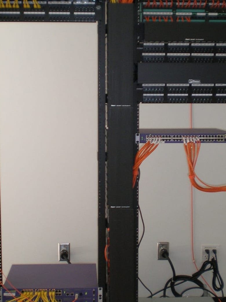 Rack de rede com patch panels e cabeamento organizado